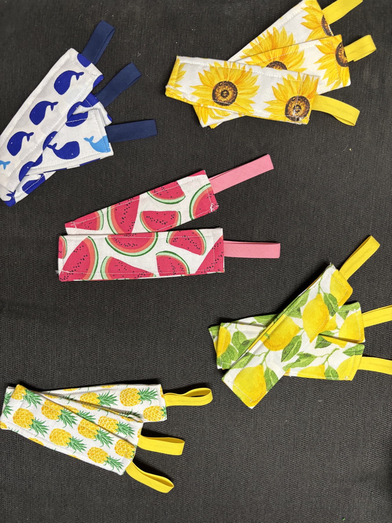 Small patterned fabric crafts with tabs in watermelon, floral, and blue designs