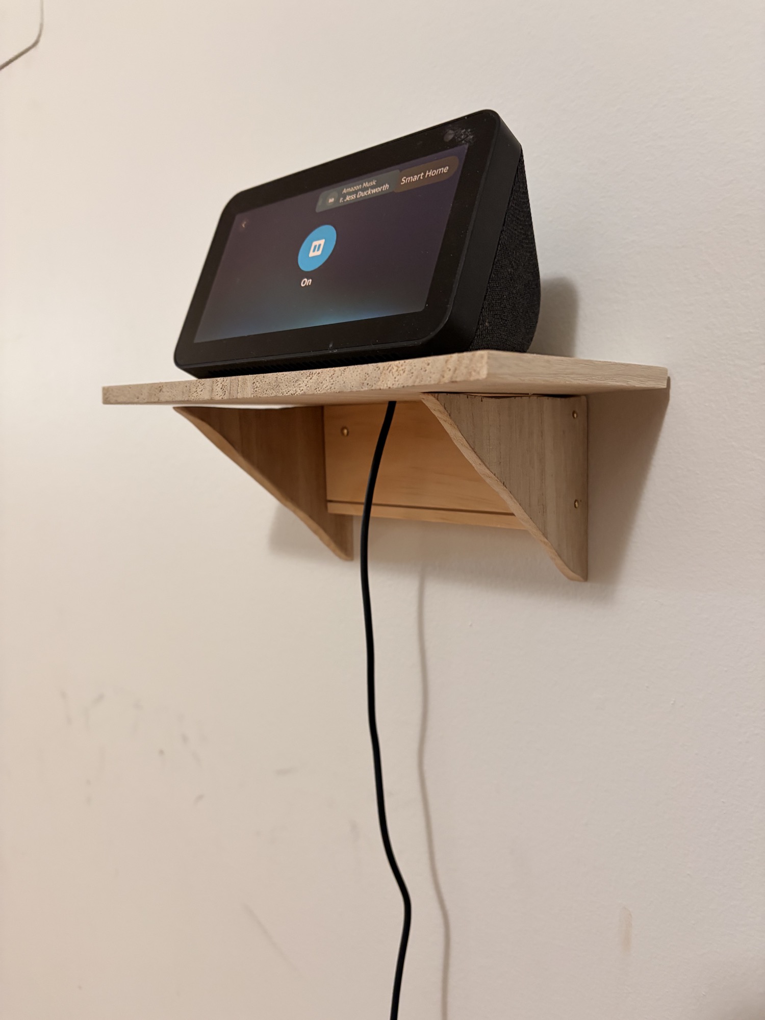 A wooden wall shelf holding a small screen