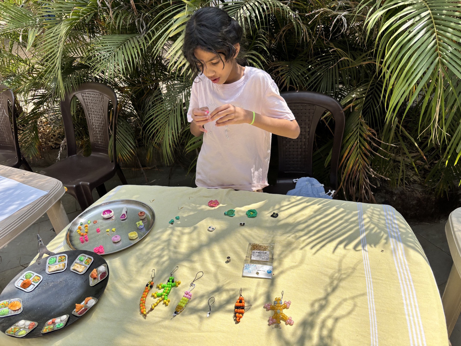 Leela making small crafts at an outdoor table
