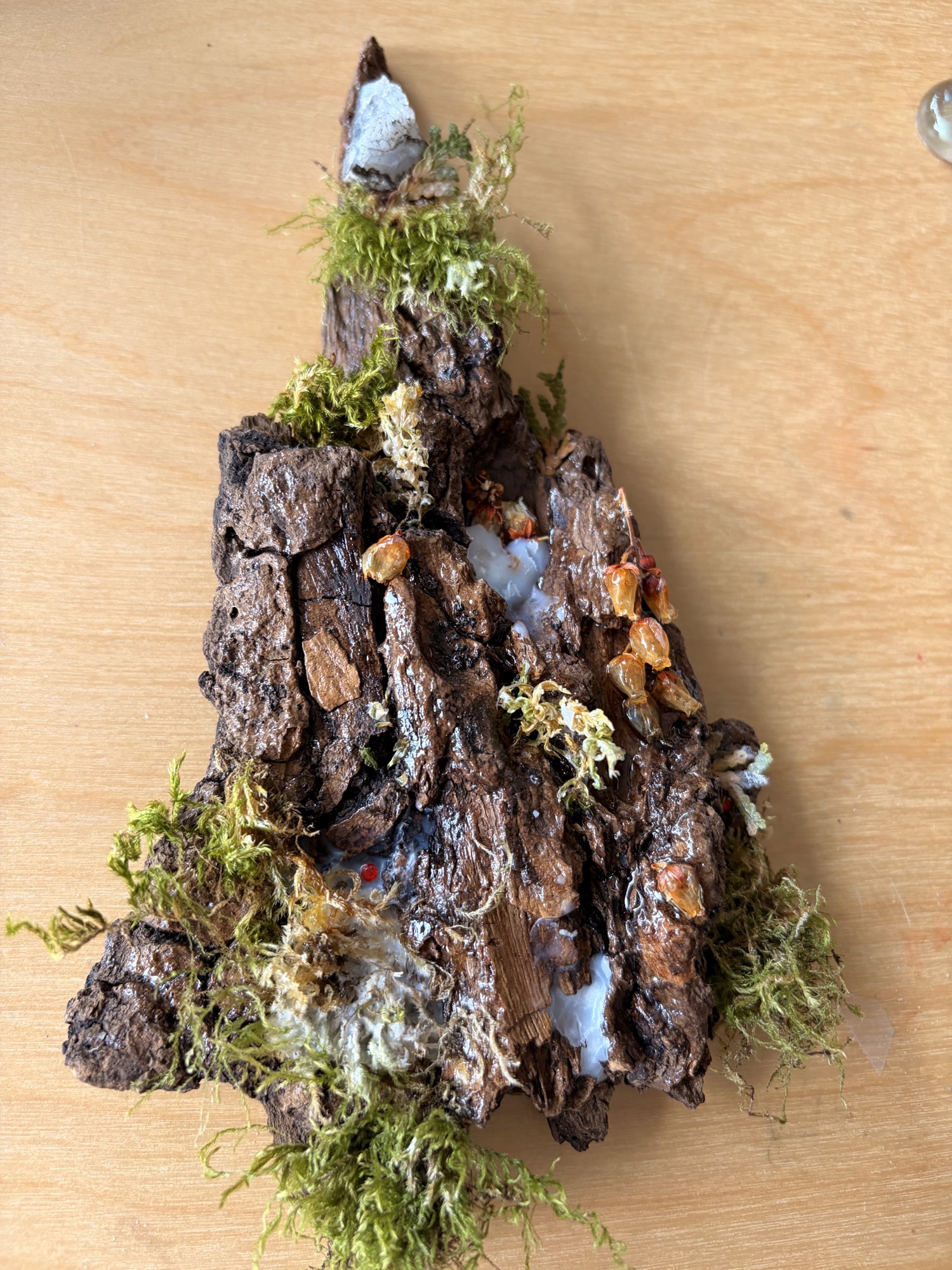 Miniature landscape made with bark, moss, and tiny decorative details